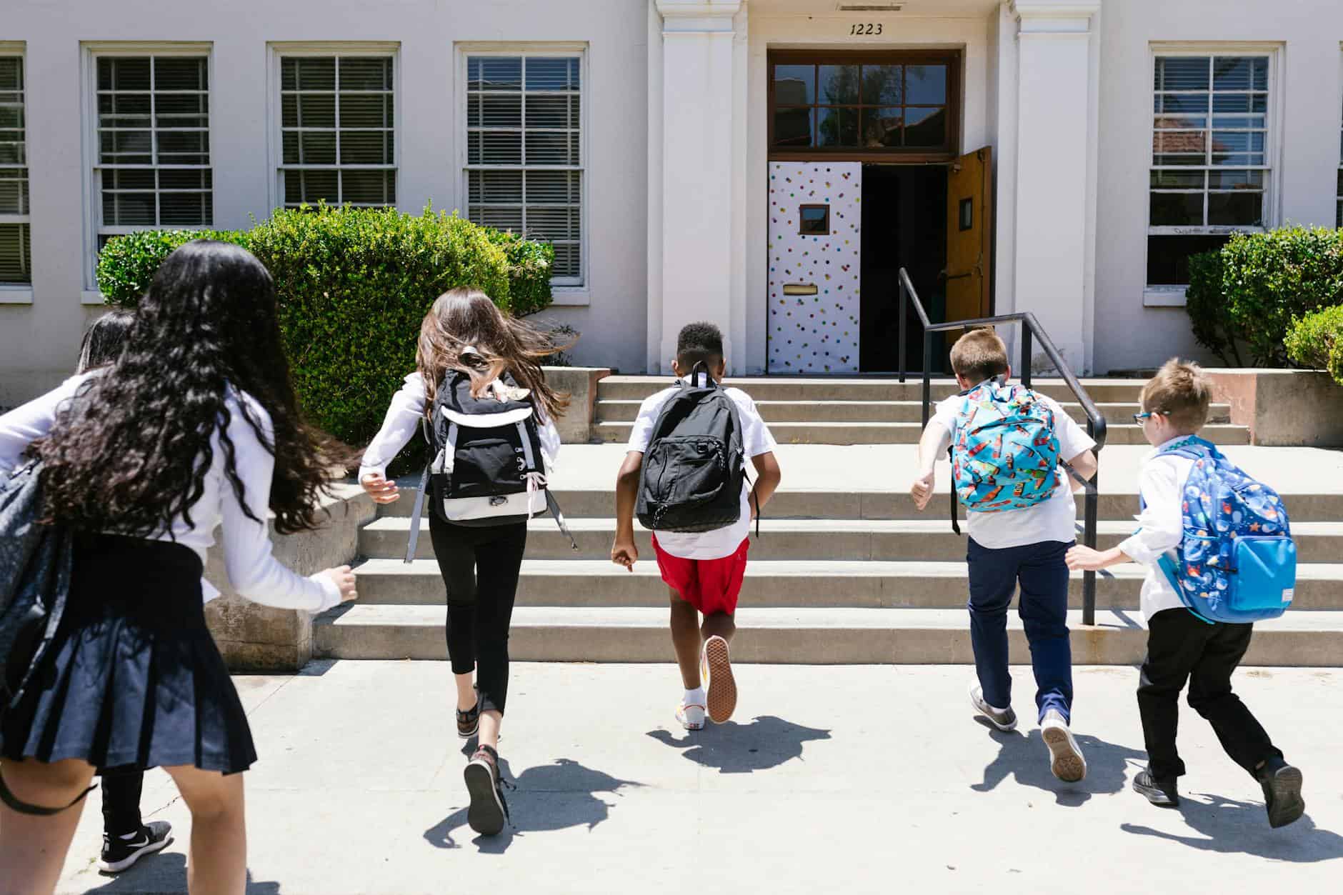 back view shot of students running to their classroom