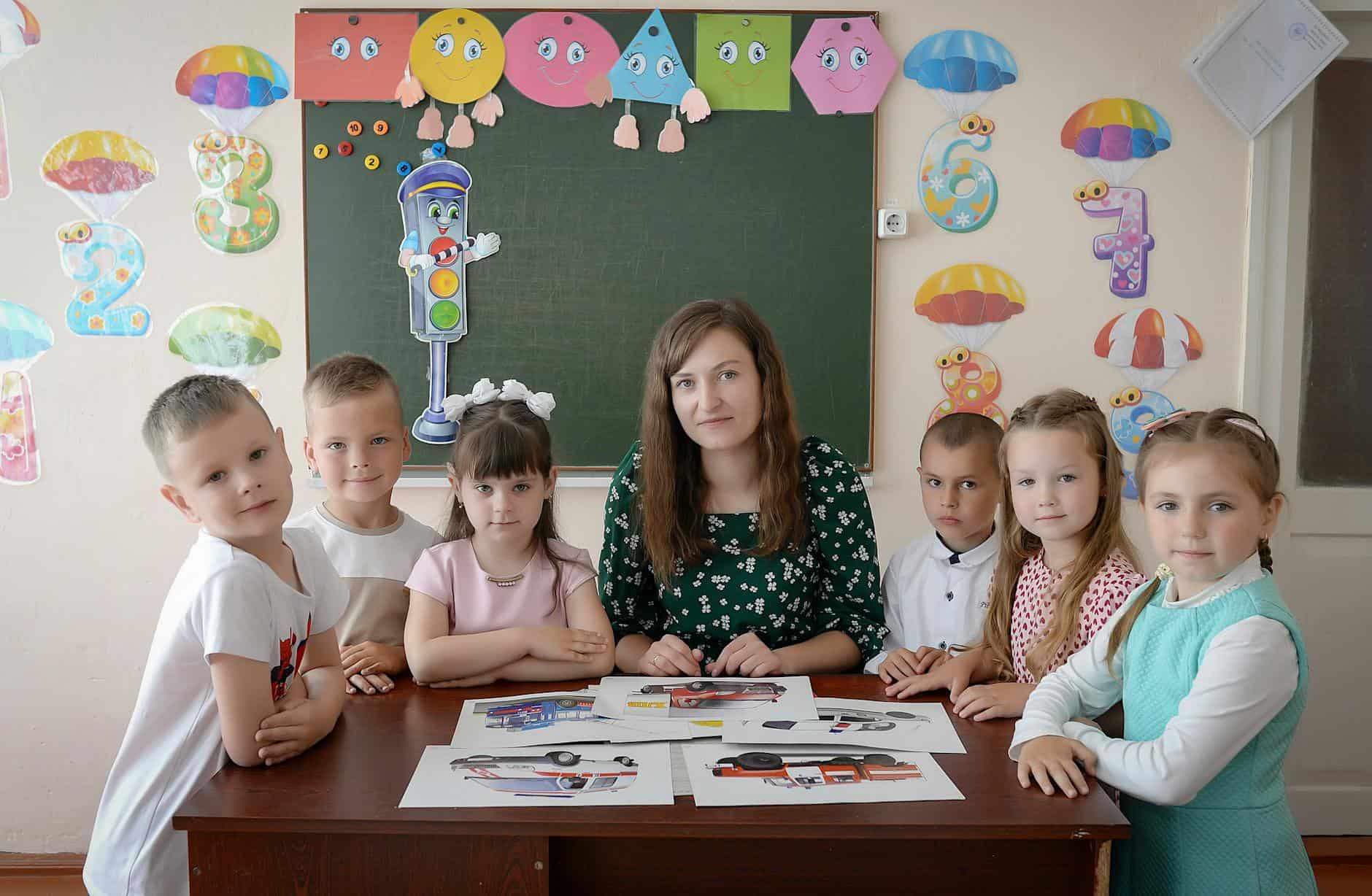 children with teacher in colorful classroom setting