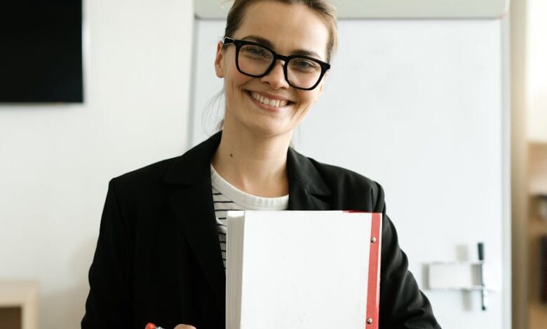 a happy woman in a black blazer and eyeglasses