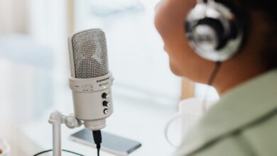 person wearing silver and black headphones holding microphone