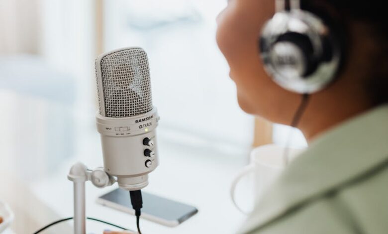 person wearing silver and black headphones holding microphone