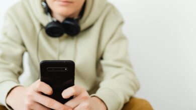 man in wearing hoodie using a smartphone