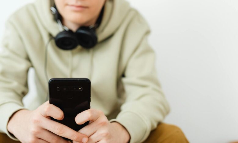 man in wearing hoodie using a smartphone