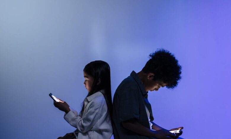 kids sitting back to back using smartphone