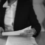 grayscale photo of a woman looking at a document