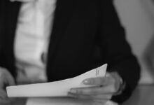 grayscale photo of a woman looking at a document