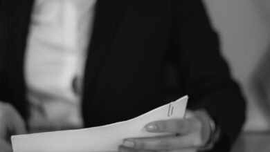 grayscale photo of a woman looking at a document