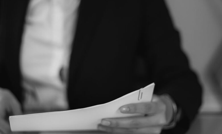 grayscale photo of a woman looking at a document