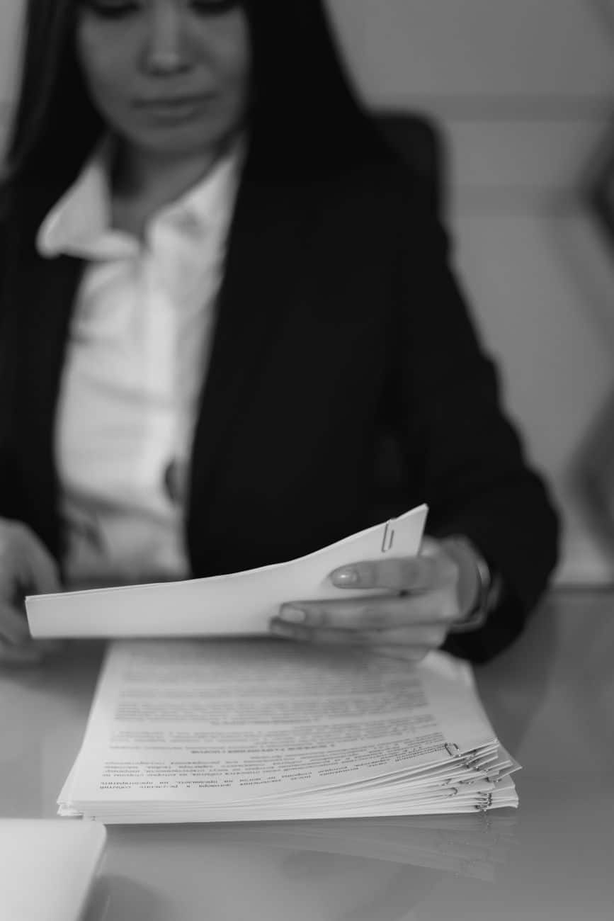 grayscale photo of a woman looking at a document