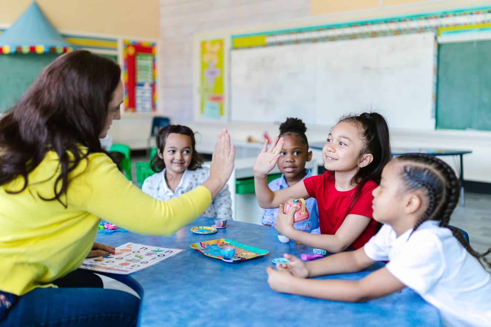 a teacher and a girl doing a high five