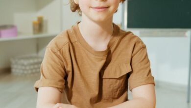 cute boy in brown shirt sitting by the yellow table