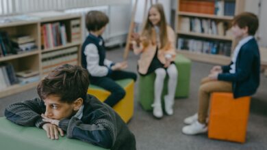 boy in gray sweater sitting on green leather couch