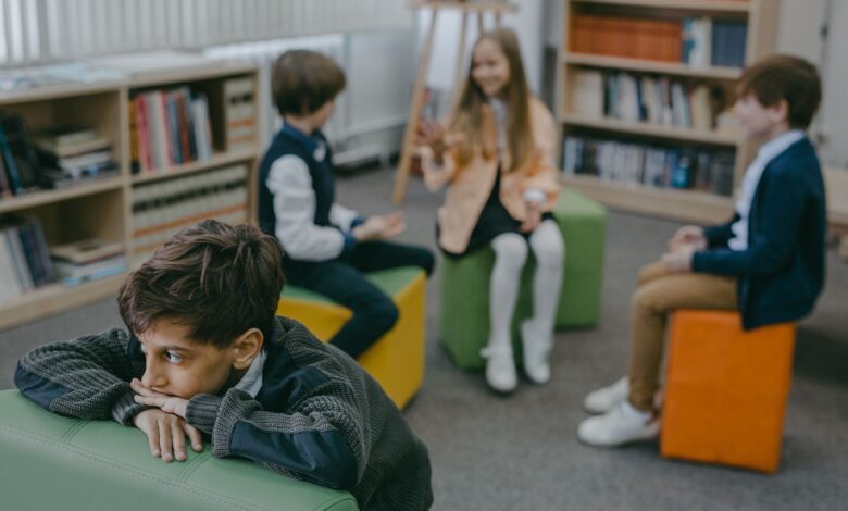 boy in gray sweater sitting on green leather couch