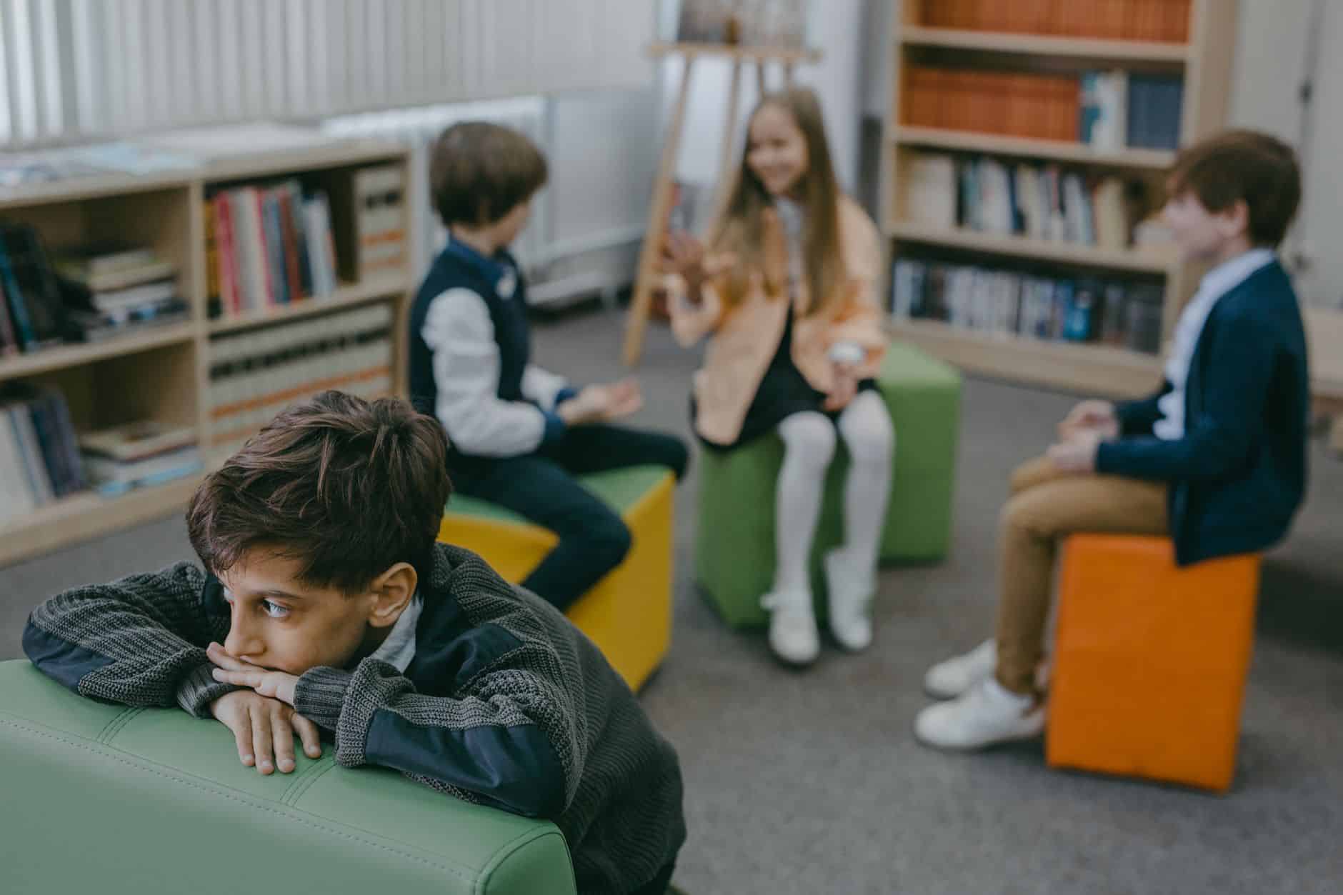 boy in gray sweater sitting on green leather couch